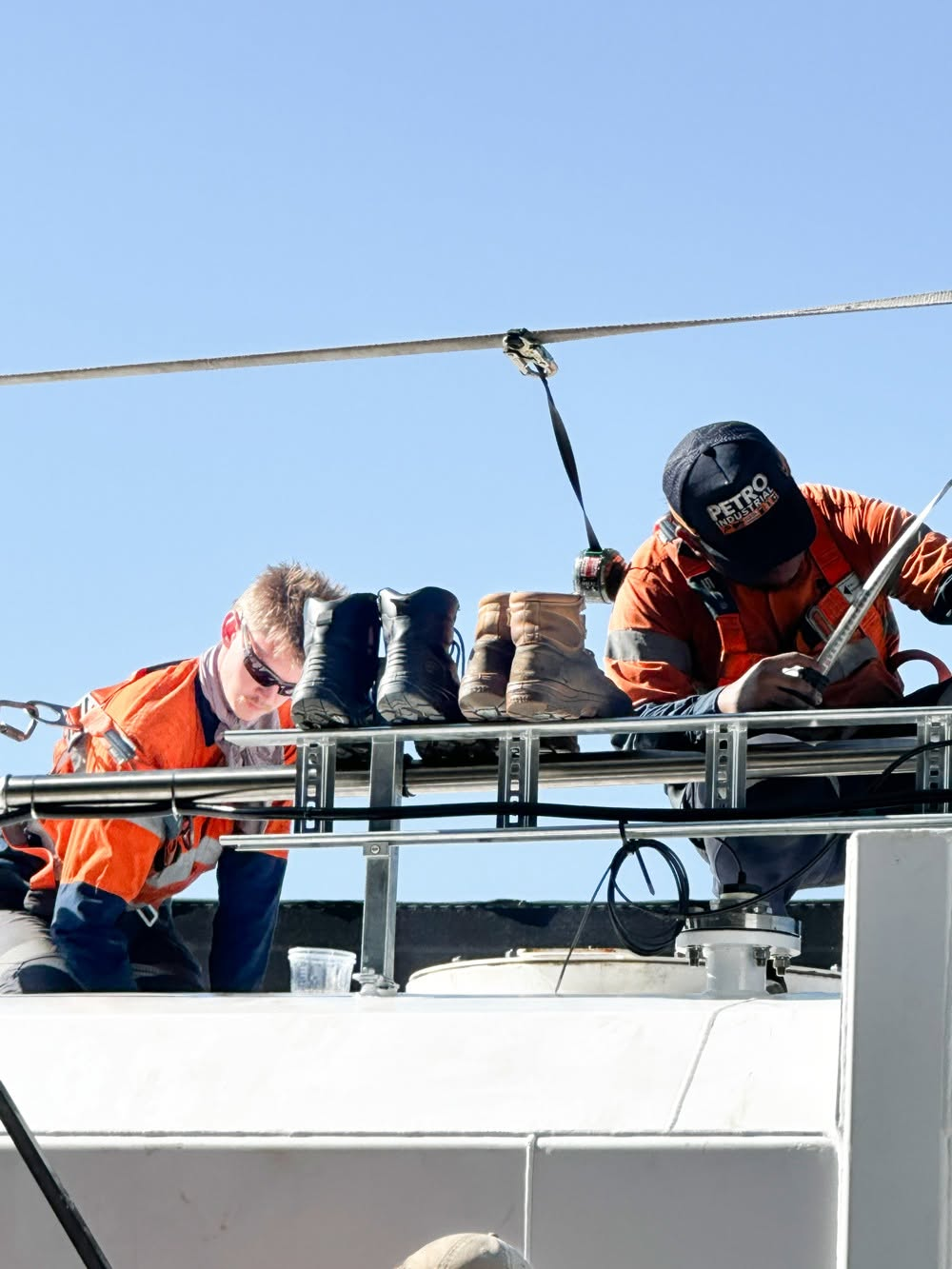 PETRO technicians servicing fuel equipment on a tank