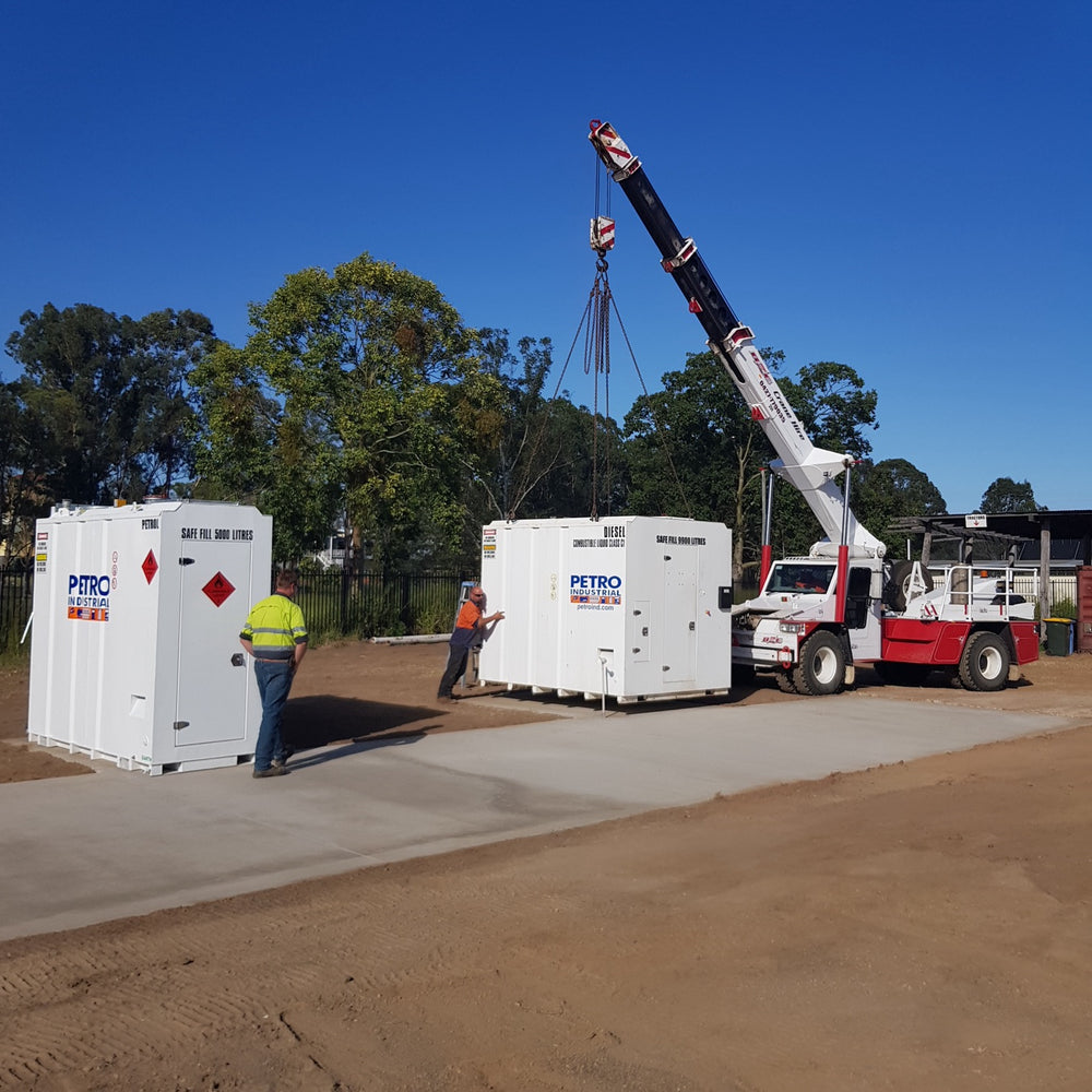 PETRO tank systems being delivered and placed on a prepared concrete pad by crane