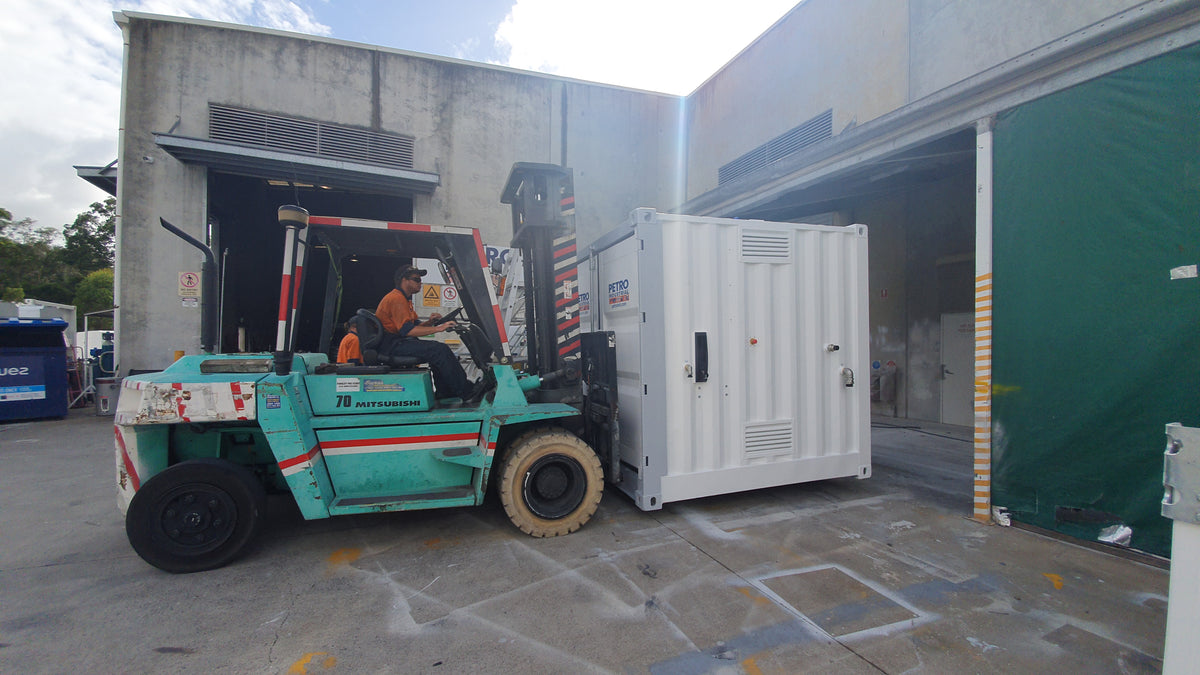 Forklift moving a white containerised fuel module