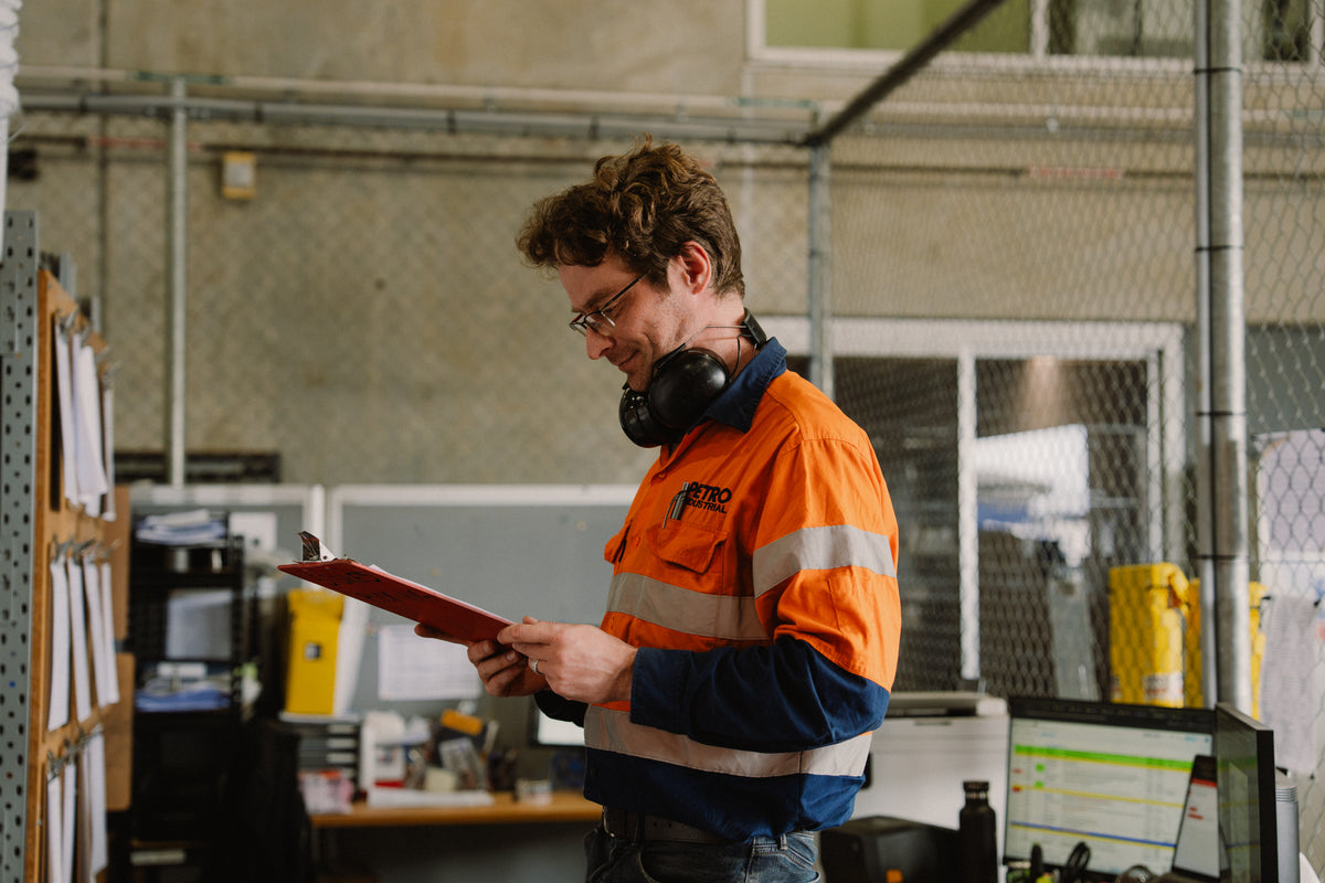 PETRO team member reviewing a clipboard in the manufacturing facility