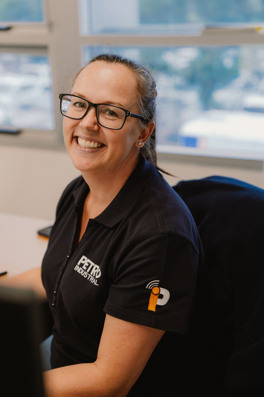 Smiling PETRO team member at her desk